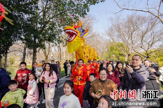舞龍隊伍穿行游客中。中新社發(fā)西溪濕地供圖