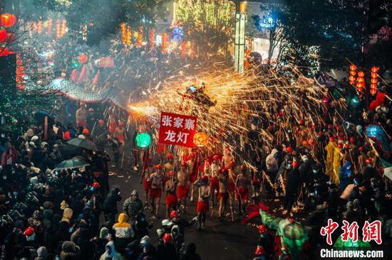 圖為舞龍者舉著龍燈接受沿街民眾噓花的“洗禮”。吳大平 攝
