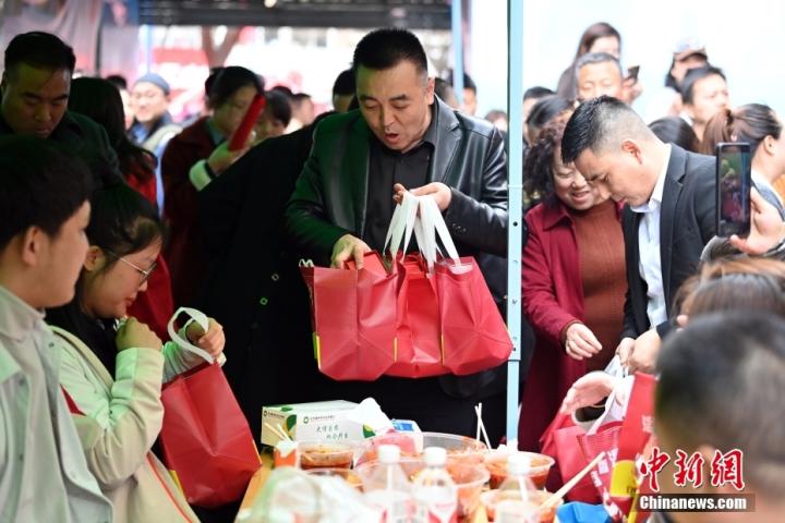 3月14日，甘肅天水，當(dāng)?shù)厝私o吃麻辣燙的游客贈(zèng)送禮品。