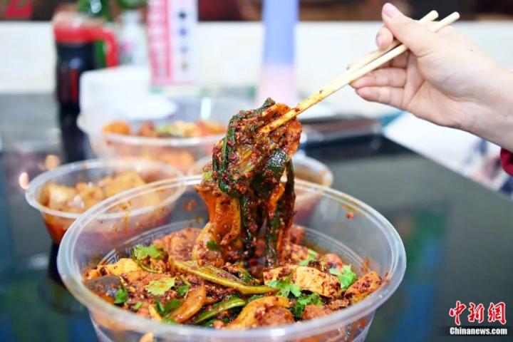 3月14日，甘肅天水，游客品嘗麻辣燙。近日，甘肅天水麻辣燙在網(wǎng)絡(luò)平臺(tái)火爆，吸引全國各地眾多游客前來品嘗。九美旦增 攝