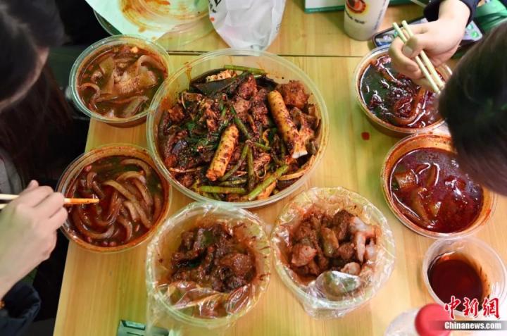 3月14日，甘肅天水，游客品嘗麻辣燙。近日，甘肅天水麻辣燙在網(wǎng)絡(luò)平臺(tái)火爆，吸引全國各地眾多游客前來品嘗。九美旦增 攝
