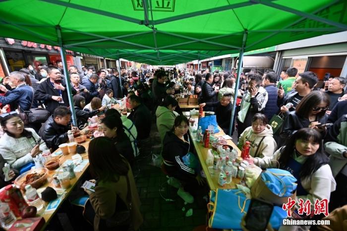 3月14日，甘肅天水，游客品嘗麻辣燙。 中新社記者 九美旦增 攝