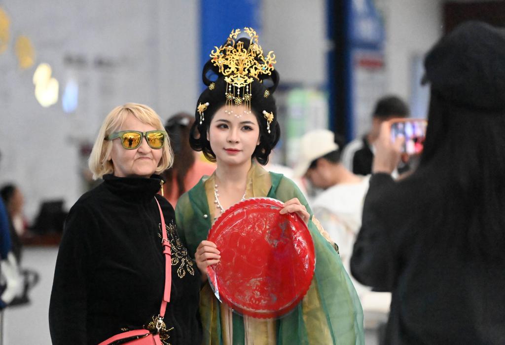 5月1日，一名外籍游客在天津國際郵輪母港客運大廳與演出人員合影。新華社記者 趙子碩 攝